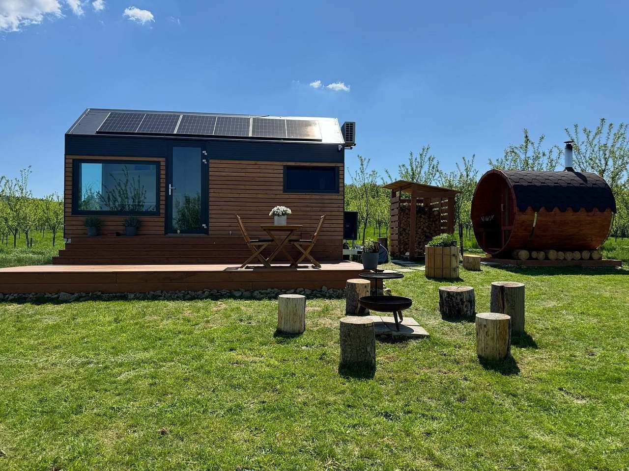 Tiny house, sudová sauna a posezení na pařezech v sadu