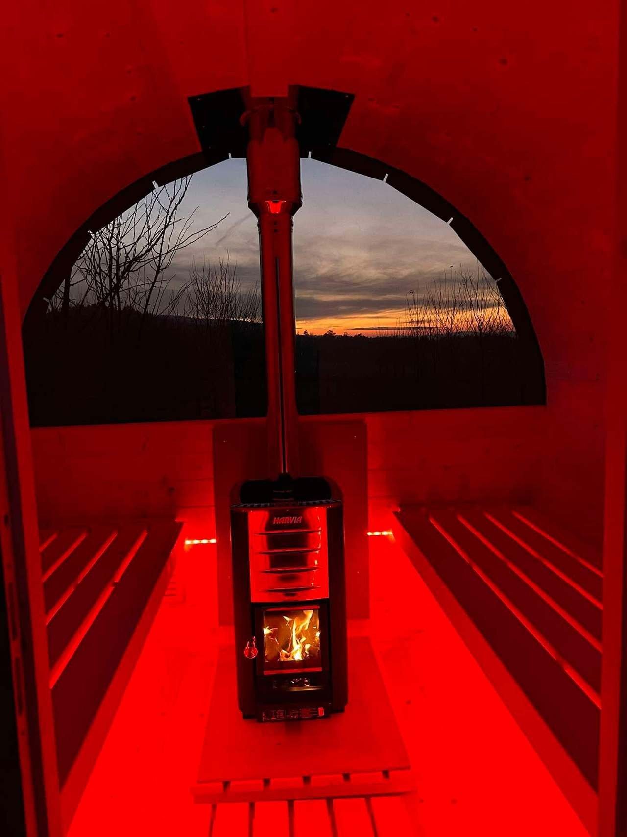 Sauna nasvícená červeně, v okně soumrak